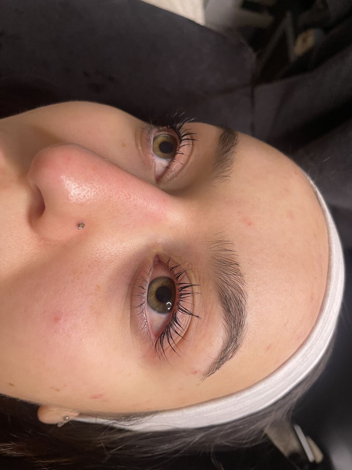 Lash lift result showing softly curled natural lashes on green eyes